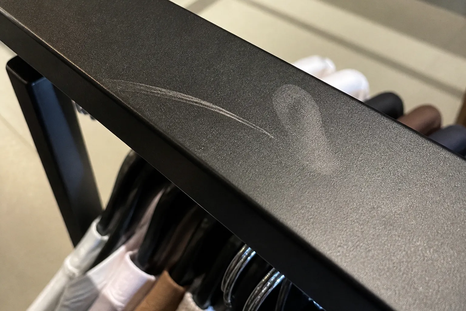 Matte black garment racks: the oil and scratch trap